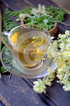 Moringa tea in cup with moringa flower and leaves
