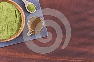 Moringa tea with powder and leaves - Moringa oleifera. Wooden background
