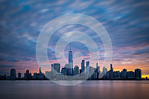 Morning atmosphere with colorful sky above Lower Manhattan cityscape.