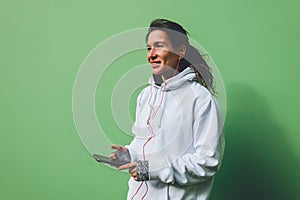 Morning autumn jog. Young beautiful woman adjusts headphones before jogging.