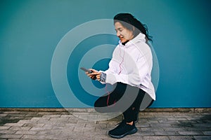 Morning autumn jog. Young beautiful woman adjusts headphones before jogging.