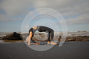 Morning beach yoga. Asian woman practicing Ardha Purvottanasana. Reverse Table Top Pose. Strong shoulders and arms. Healthy life