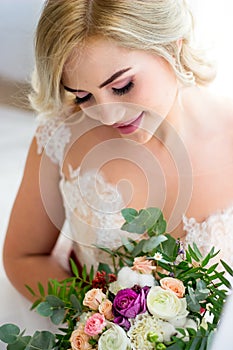 The morning of a beautiful bride dressed in a peignoir surrounded by flowers
