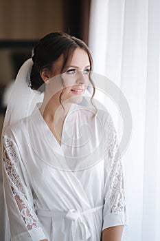 Morning of beautiful bride. Woman in white negligee in hotel