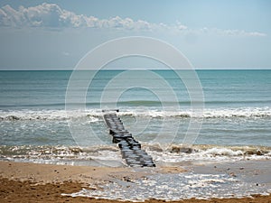 Morning on Bibione beach in italy, sand dunes and stony breakwater