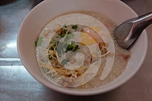Morning Breakfast with a Chinese Cuisine Pork Congee with egg Asian rice porridge bowl