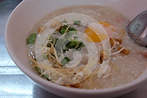 Morning Breakfast with a Chinese Cuisine Pork Congee with egg Asian rice porridge bowl