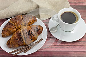 Morning snack with aromatic black coffee and French croissants.