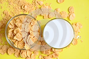 Morning breakfast fresh whole grain cereal, cornflakes with milk on yellow background, cornflakes bowl breakfast food and snack