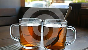 Morning breakfast. Two transparent glasses cups of tea with boiling water of tea that steams