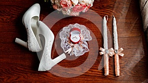 Morning of the bride. Bridal bouquet. Wedding candles in the church. Wedding rings in a red box. White shoes of the