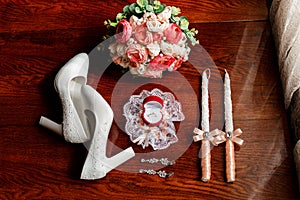 Morning of the bride. Bridal bouquet. Wedding candles in the church. Wedding rings in a red box. White shoes of the