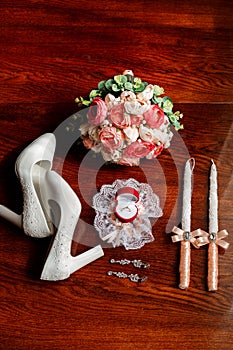 Morning of the bride. Bridal bouquet. Wedding candles in the church. Wedding rings in a red box. White shoes of the