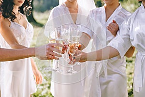 Morning of the bride. Close up of glasses of champagne in the hands of bridesmaids and brides