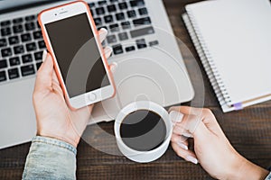 Morning business woman. Laptop on the desk, phone and a cup of coffee in female hands. Horizontal frame