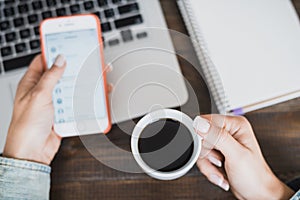 Morning business woman. Laptop on the desk, phone and a cup of coffee in female hands. Horizontal frame