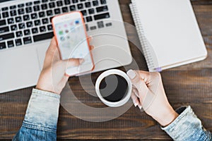 Morning business woman. Laptop on the desk, phone and a cup of coffee in female hands. Horizontal frame
