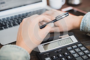 Morning business woman. Laptop, phone and calculator in female hands. Horizontal frame