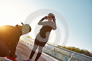 Morning cardio. Active young african couple preparing before jogging while standing on the bridge. Man tying shoelaces