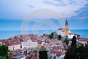 Morning cityscape of city of Piran, Slovenia with big dominant St. George`s Parish Church and main square