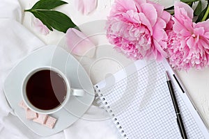 Morning coffee cup and notepad in bright colours with pink flowers