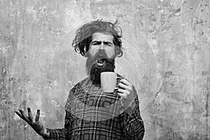 Morning coffe. singing bearded man pulling stylish fringe hair with blue cup