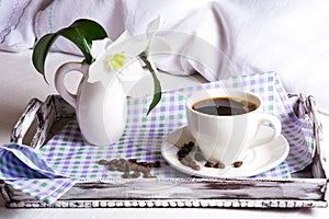 Morning coffee in bed with white lily flowers