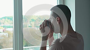 Morning coffee. Considered caucasian man. New day inspiration. Calm thoughtful guy with cup hot beverage looking window