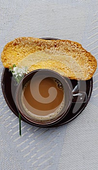 Morning coffee. A cup of coffe, bagelan breadand flower