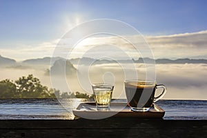 Morning coffee cup with mountain view and mist