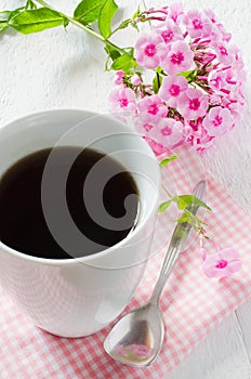 Morning coffee or cup of tea with pink flowers.