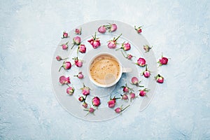 Morning coffee and dry rose flowers on blue vintage table top view in flat lay style. Cozy breakfast on Mother or Woman day.