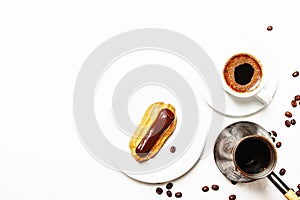 Morning coffee with eclair cake, white background, top view