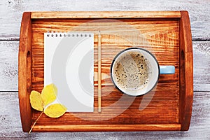 Morning coffee and empty notebook on wooden tray top view. Cozy autumn breakfast. Fall bucket list. Flat lay.