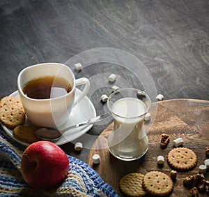 Morning coffee with marshmallows, cookies and milk. Dark wooden background.