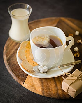 Morning coffee with marshmallows, cookies and milk. Dark wooden background.