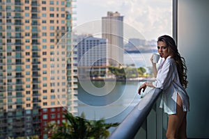 Morning coffee. Sensual woman enjoy coffee at terrace balcony on summer vacation time. Elegant woman drinking coffee at