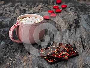 Morning coffee with Valentine's Day in a pink mug and dark chocolate