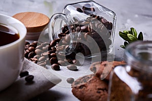 Morning coffee in white cup, chocolate chips cookies on homespun napkin, close-up, selective focus