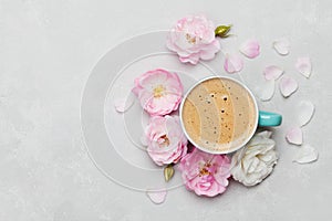 Morning Cup of coffee and a beautiful roses flowers on light background, top view. Cozy Breakfast. Flat lay style.