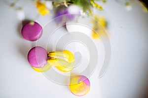 Morning cup of coffee, cake macaron, gift or present box and flower on light table from above. Beautiful breakfast. Flat lay style