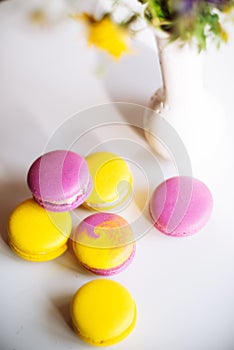 Morning cup of coffee, cake macaron, gift or present box and flower on light table from above. Beautiful breakfast. Flat lay style