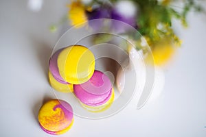 Morning cup of coffee, cake macaron, gift or present box and flower on light table from above. Beautiful breakfast. Flat lay style