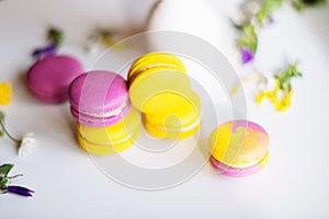 Morning cup of coffee, cake macaron, gift or present box and flower on light table from above. Beautiful breakfast. Flat lay style