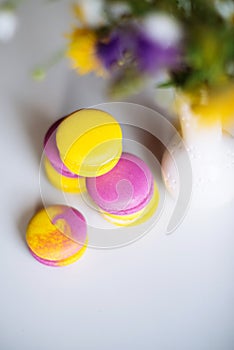 Morning cup of coffee, cake macaron, gift or present box and flower on light table from above. Beautiful breakfast. Flat lay style