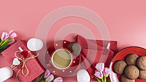 Morning cup of coffee, chocolate cake, gift or present box, candles and flower on pink table from above. Stop motion video