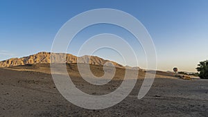 Morning in the desert. A bright balloon rises above the sand dunes.