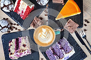 Top view on colorful cake with coffe on white table. Different dessrts.