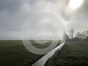 Morning fog on farm in Dutch landscape.