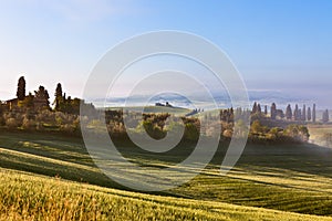 Morning fog view on Tuscan farmhouse